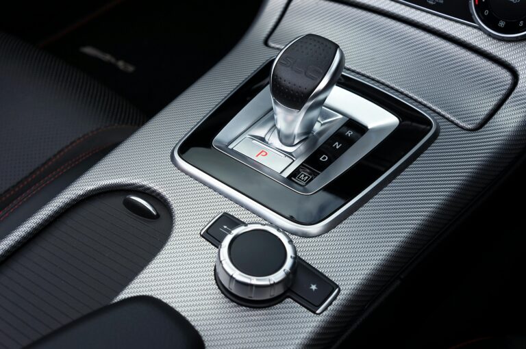 Close-up view of a luxury car gear shift lever in a Mercedes-Benz interior. Modern automotive design with chrome detailing.